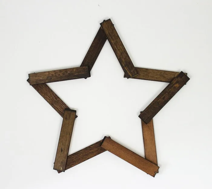 Make this pretty wooden star DIY Christmas decoration for your holiday mantle! It's so easy to make and looks so pretty when it's done!